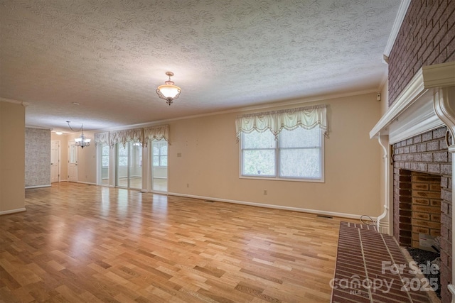 unfurnished living room featuring a textured ceiling, light wood-style flooring, a brick fireplace, and ornamental molding