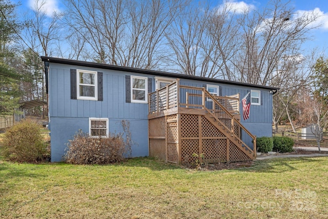 rear view of property with a deck and a yard