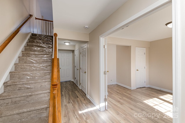 stairway with baseboards and wood finished floors