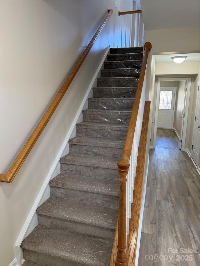 stairs featuring baseboards and wood finished floors