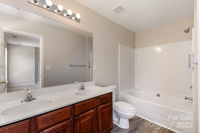 full bathroom featuring visible vents, a sink, toilet, and double vanity