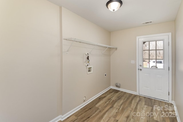 laundry area featuring laundry area, baseboards, visible vents, wood finished floors, and hookup for a washing machine