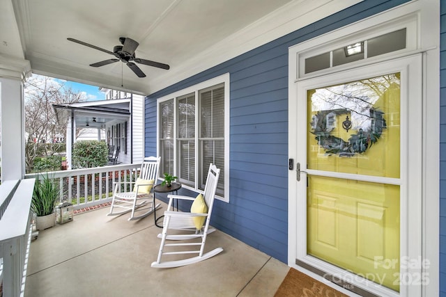 view of exterior entry with a ceiling fan and covered porch