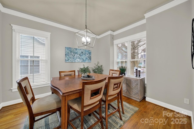 dining space with a wealth of natural light, baseboards, ornamental molding, and light wood-type flooring