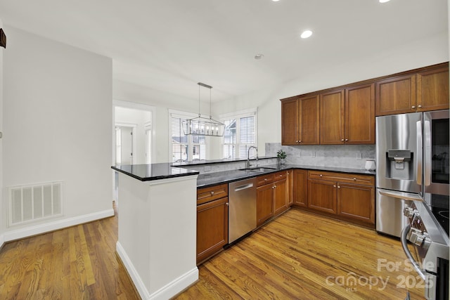 kitchen featuring visible vents, a peninsula, appliances with stainless steel finishes, and pendant lighting