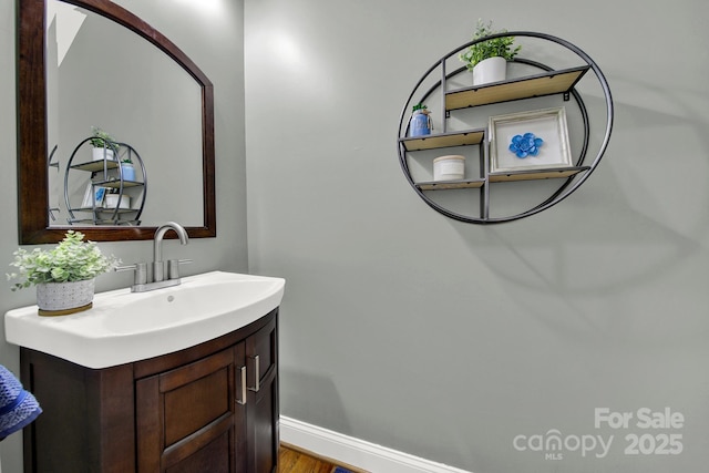 bathroom featuring vanity, baseboards, and wood finished floors