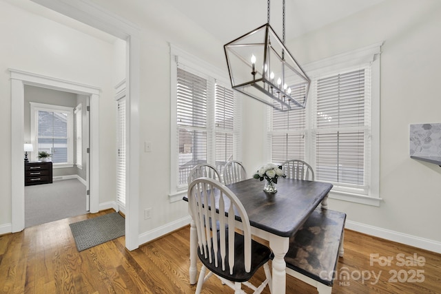 dining room featuring baseboards, a chandelier, and wood finished floors