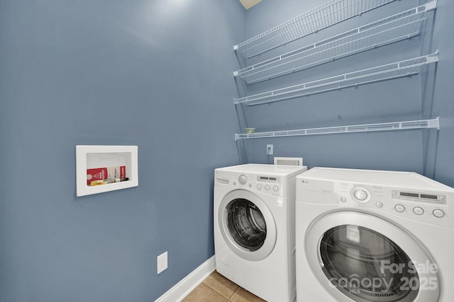 laundry area with baseboards, light tile patterned floors, laundry area, and separate washer and dryer