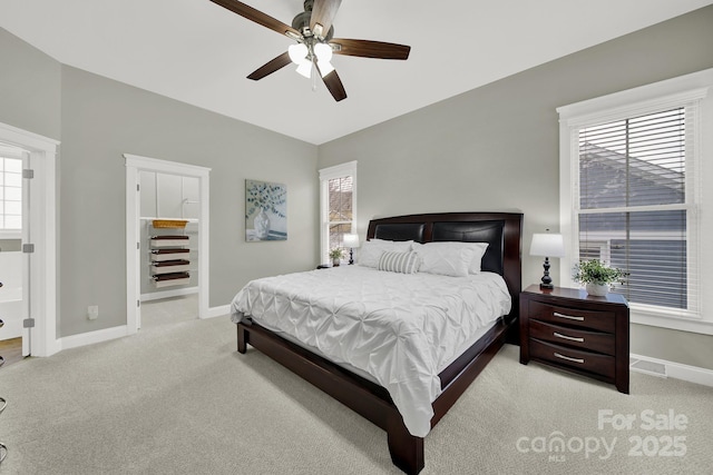 bedroom featuring baseboards, ceiling fan, visible vents, and light carpet