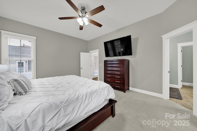 bedroom with baseboards, ceiling fan, and light carpet