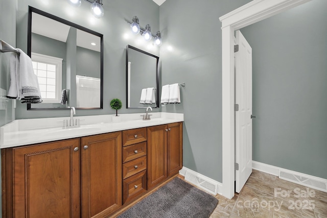 bathroom featuring double vanity, baseboards, visible vents, and a sink