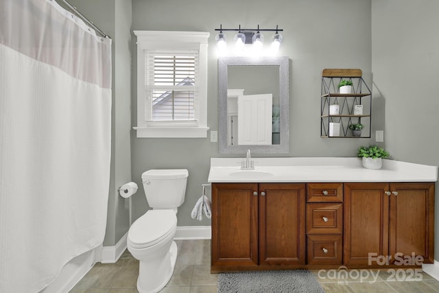 bathroom with baseboards, vanity, toilet, and tile patterned flooring