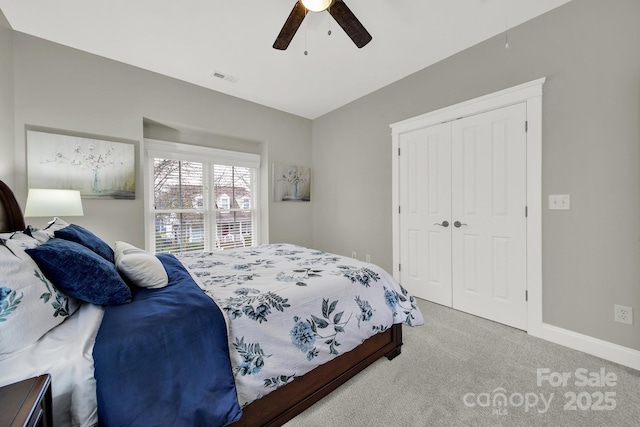 carpeted bedroom featuring ceiling fan, visible vents, a closet, and baseboards