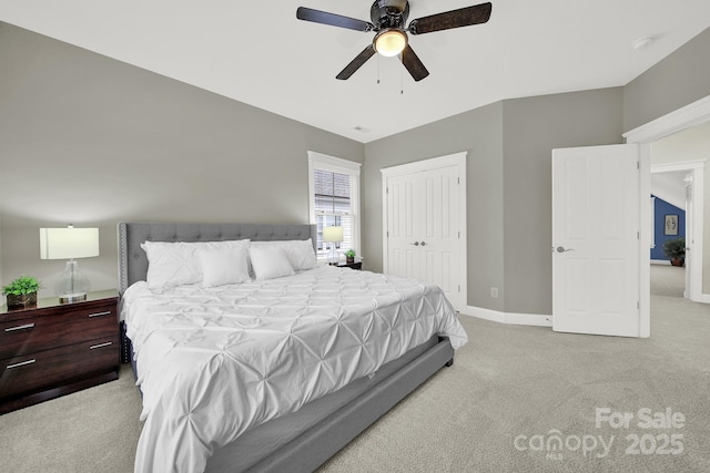 bedroom with light colored carpet, ceiling fan, a closet, and baseboards