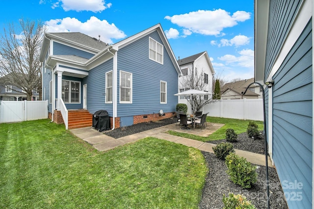 back of property with crawl space, a patio, roof with shingles, a yard, and a fenced backyard