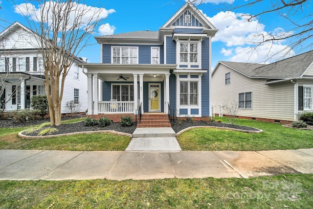 victorian-style house featuring a ceiling fan, a front yard, and covered porch