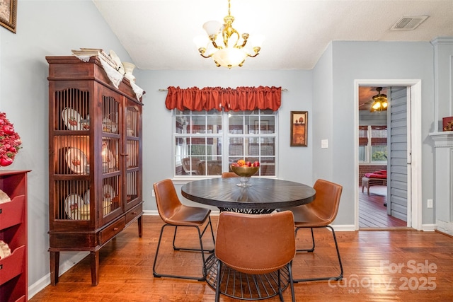 dining room with a notable chandelier, visible vents, plenty of natural light, and hardwood / wood-style flooring