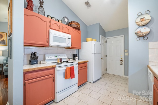 kitchen featuring visible vents, tasteful backsplash, white appliances, light countertops, and lofted ceiling