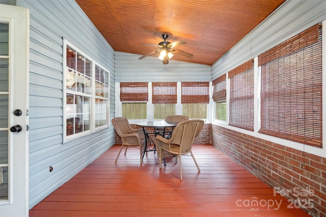 sunroom featuring wood ceiling and a ceiling fan