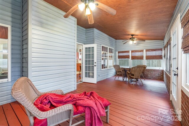 sunroom featuring wooden ceiling and a ceiling fan