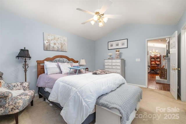 bedroom with vaulted ceiling, ceiling fan with notable chandelier, baseboards, and light carpet