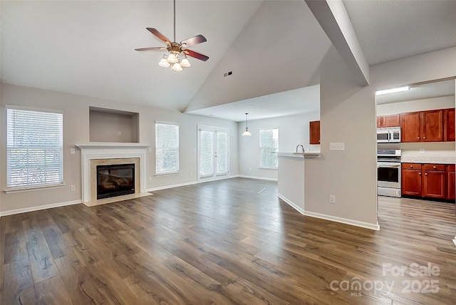 unfurnished living room featuring a premium fireplace, dark wood-type flooring, ceiling fan, high vaulted ceiling, and baseboards