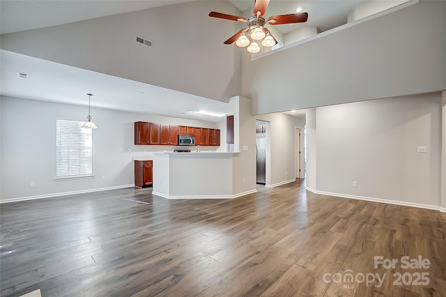 unfurnished living room with visible vents, baseboards, dark wood-style floors, ceiling fan, and high vaulted ceiling