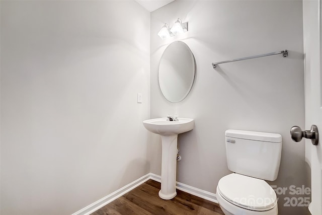 bathroom featuring wood finished floors, toilet, and baseboards