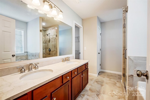 full bath featuring a stall shower, a sink, a spacious closet, and double vanity