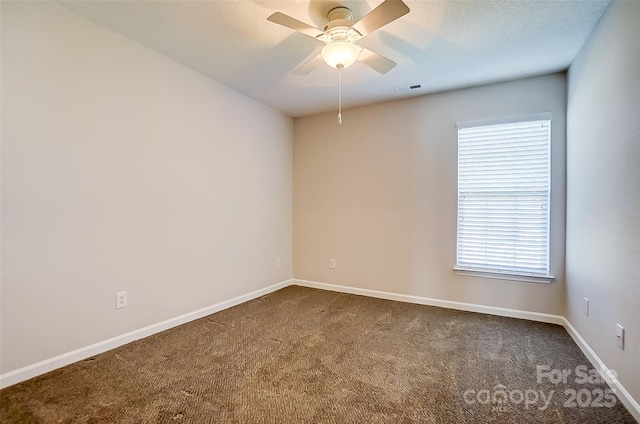 empty room with a textured ceiling, carpet flooring, a ceiling fan, visible vents, and baseboards