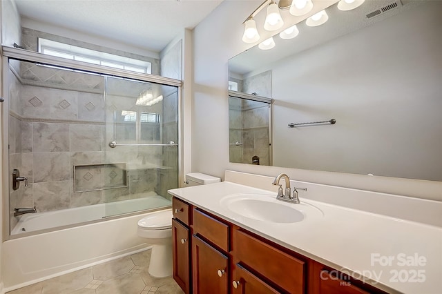 bathroom featuring visible vents, toilet, enclosed tub / shower combo, vanity, and tile patterned flooring