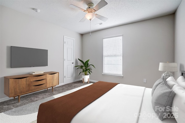 carpeted bedroom featuring a textured ceiling, a ceiling fan, visible vents, and baseboards