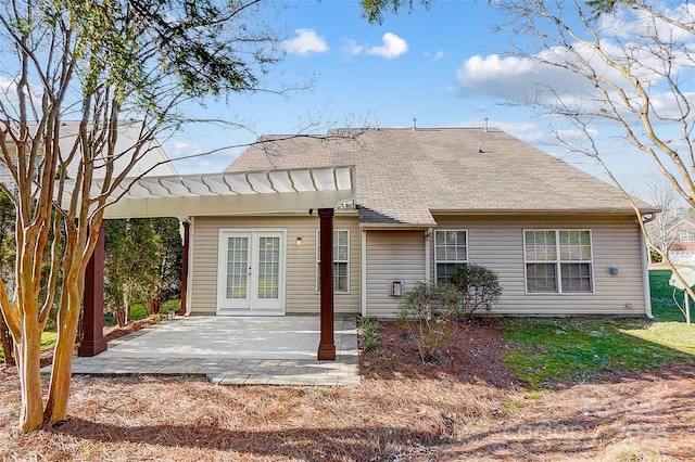 rear view of house with french doors, roof with shingles, and a patio