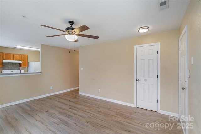 empty room featuring ceiling fan and light hardwood / wood-style floors