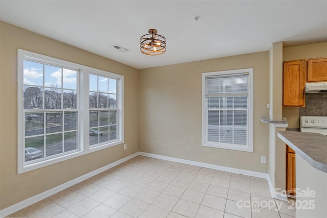 unfurnished dining area with light tile patterned flooring and a mountain view