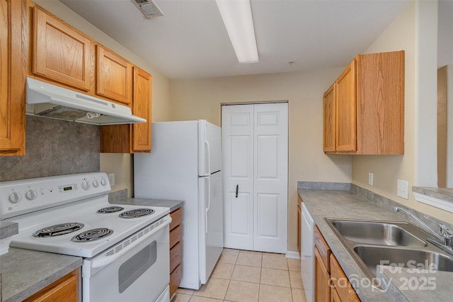 kitchen featuring white appliances, sink, and light tile patterned floors