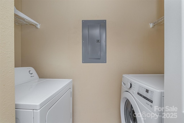 clothes washing area featuring electric panel and washer and clothes dryer