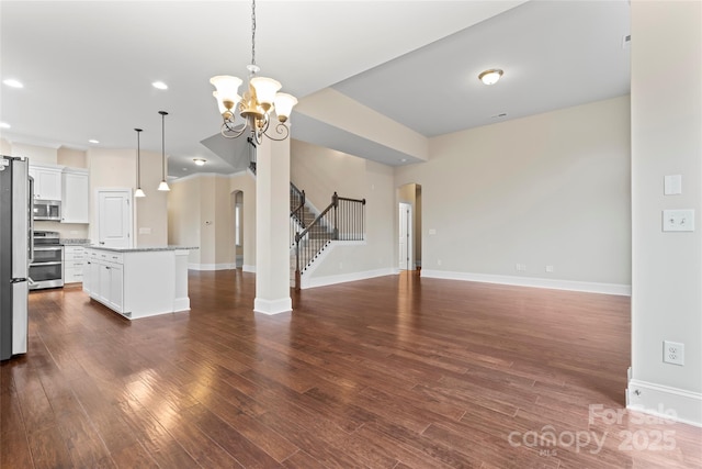 unfurnished living room with dark wood-type flooring and a chandelier