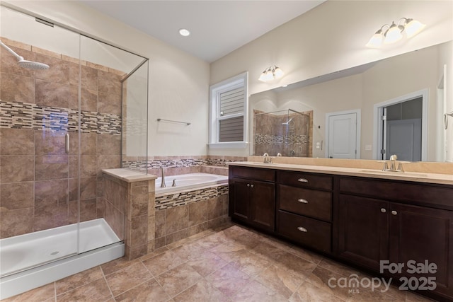 bathroom featuring vanity and independent shower and bath