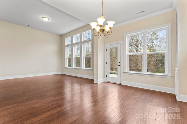 unfurnished dining area featuring crown molding, dark hardwood / wood-style flooring, and a chandelier