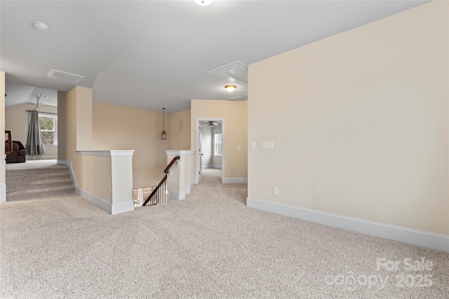 carpeted spare room with vaulted ceiling