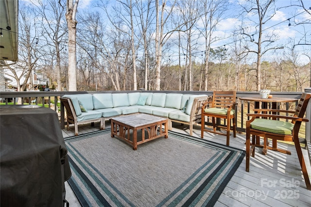 wooden terrace featuring area for grilling and an outdoor living space