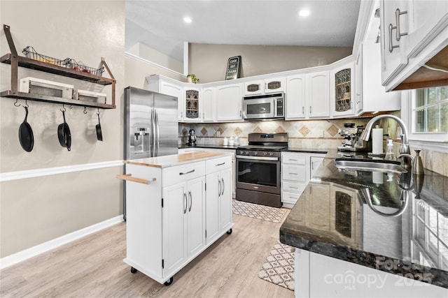 kitchen featuring white cabinetry, stainless steel appliances, sink, and a kitchen island