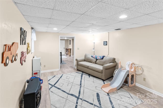 living room featuring a drop ceiling and light wood-type flooring