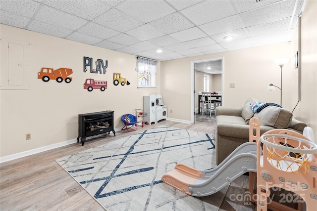 living room with electric panel, light hardwood / wood-style flooring, and a drop ceiling