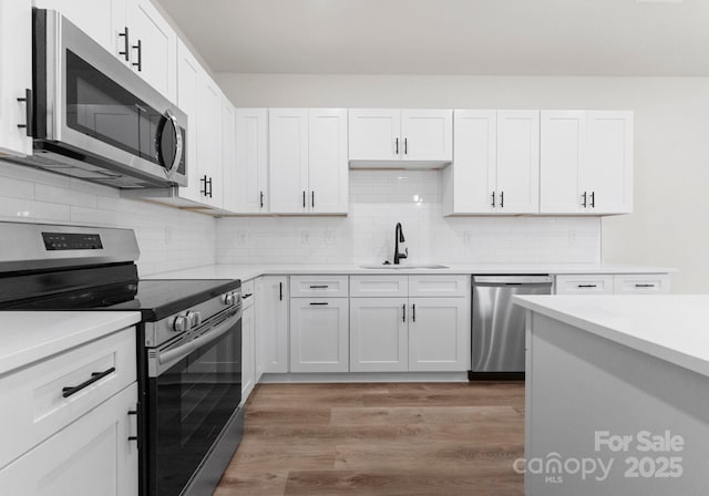 2825 New Pineola Rd Unit 7A, Charlotte, NC 28208 - kitchen with a sink, light wood-type flooring, decorative backsplash, light countertops, and appliances with stainless steel finishes