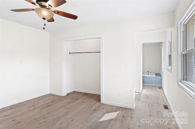 unfurnished bedroom with ceiling fan, light hardwood / wood-style floors, and a closet