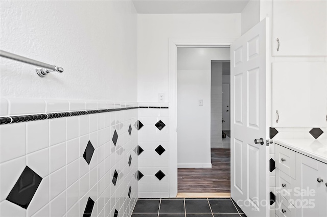 bathroom featuring vanity, tile patterned flooring, and tile walls