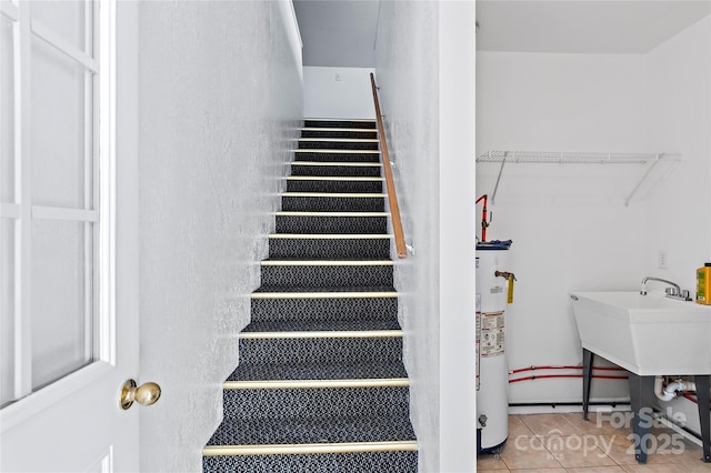 stairway with tile patterned flooring and gas water heater