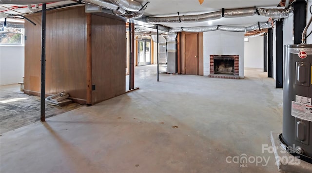 basement with water heater, a healthy amount of sunlight, heating unit, and a fireplace